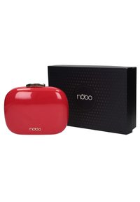 Pochette rouge brillante de forme arrondie avec une fermeture à clapet dorée. Comprend une boîte noire avec un logo circulaire et un motif triangulaire.