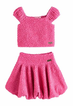 Roosa tekstuuriga kahepoolsed rõivad, millel on lühikesed paapoolse lõikega varrukad ja lai kella kujuline seelik, mõlemal väike metallist brändimärk.