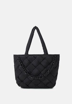 Bolso tote negro acolchado con asas acolchadas y un detalle decorativo de cadena negra en la parte frontal, exhibido sobre un fondo blanco liso.