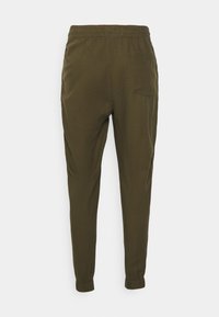 Pantalons fuselés légers vert olive avec une taille élastique, des poignets aux chevilles et une poche arrière unique. Texture lisse et coupe décontractée.