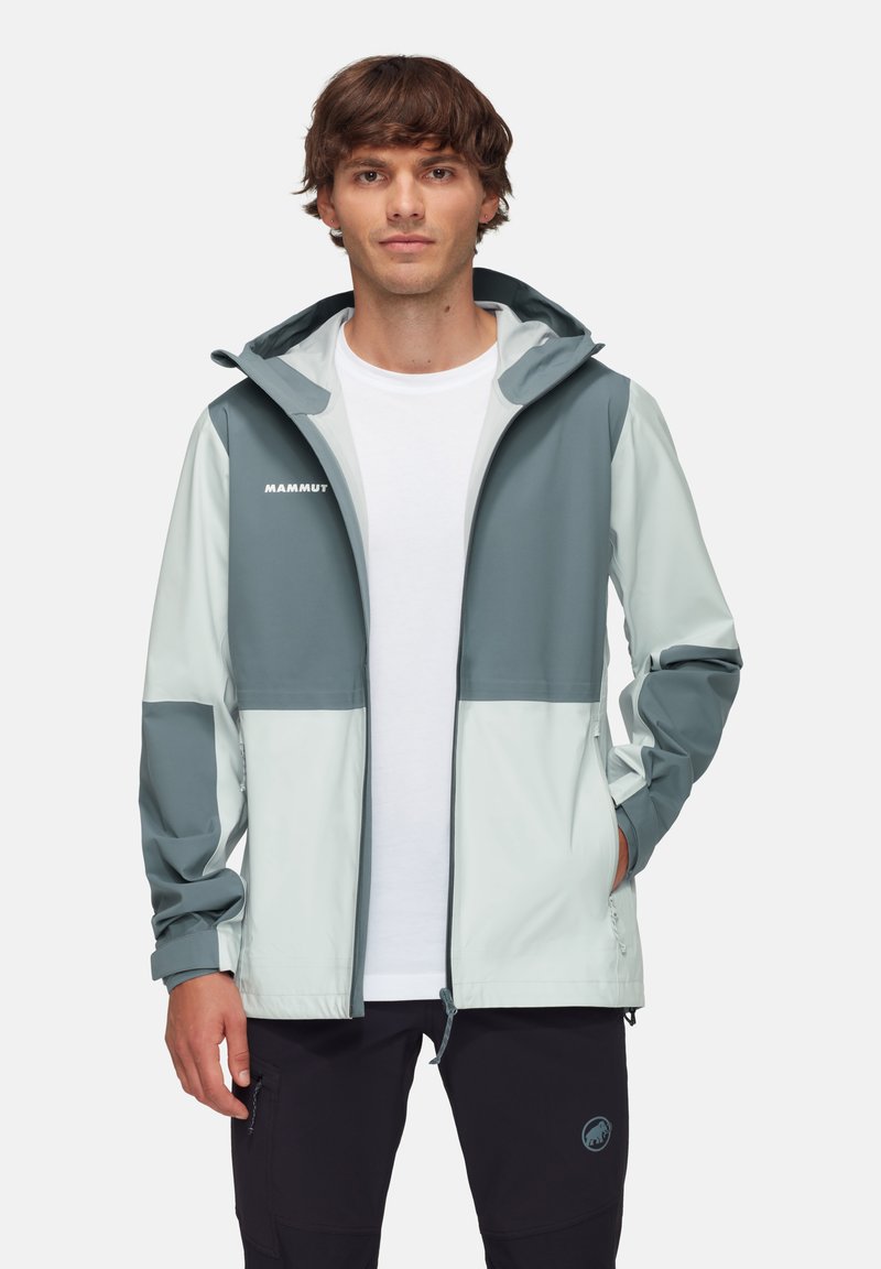Veste légère bicolore en menthe pâle et vert téal, dotée d'une capuche, de poches zippées et d'une finition lisse. Logo affiché sur la poitrine.