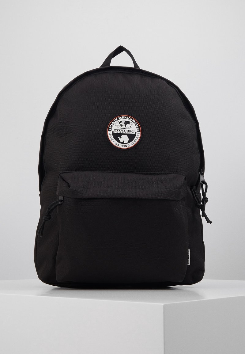 Sac à dos noir avec poche zippée à l'avant et écusson rond blanc et rouge portant la mention « Napapijri Antarctic Research Program ».