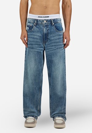Light blue oversized denim jeans feature a straight-leg design with fading, five pockets, and a contrasting white logo waistband.