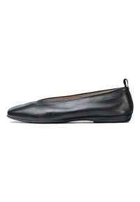 Bailarinas de cuero negro con punta afilada, diseño minimalista, textura suave y un pequeño tacón; presenta un detalle de marca cerca del tacón.