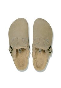 Beige mockasins i mocka med justerbart rem, mjukt foder i päls och rundad form. Platt sula för enkel användning.
