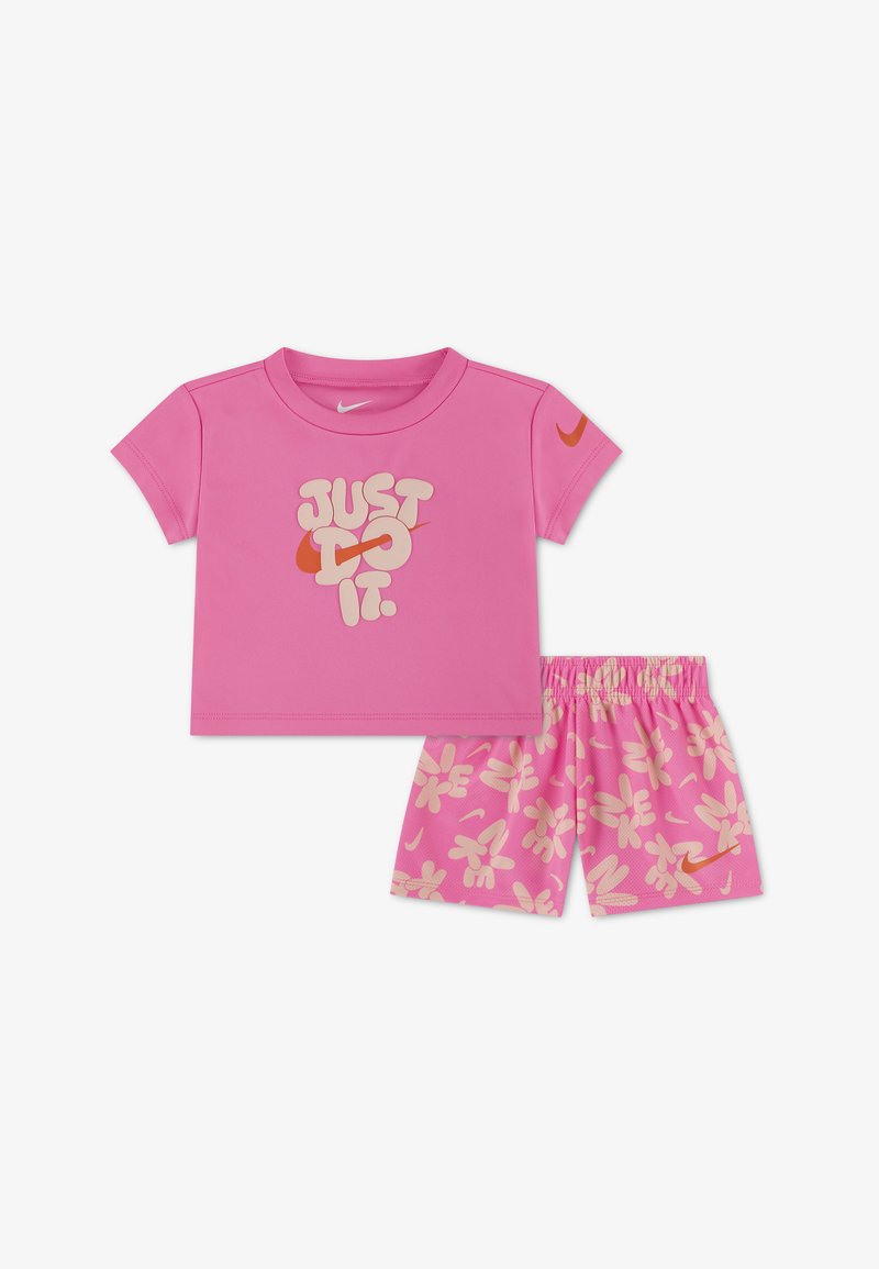 Ροζ σύνολο για νήπια με κοντομάνικο μπλουζάκι που φέρει το κείμενο «JUST DO IT.» και σορτς με ανοιχτό ροζ floral μοτίβο και πορτοκαλί λογότυπα της Nike.