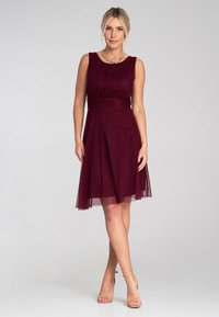 Bordeauxfarbendes ärmelloses Kleid mit tailliertem Oberteil, gerafftem Taillenbund und weit ausgestellt Rock, mit transparenter Überlagerung und glatter Oberfläche.