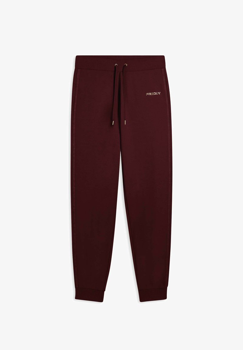 Pantaloni della tuta color marsala realizzati in tessuto morbido, con vita elastica e cordoncino, righe laterali e un piccolo dettaglio in oro.