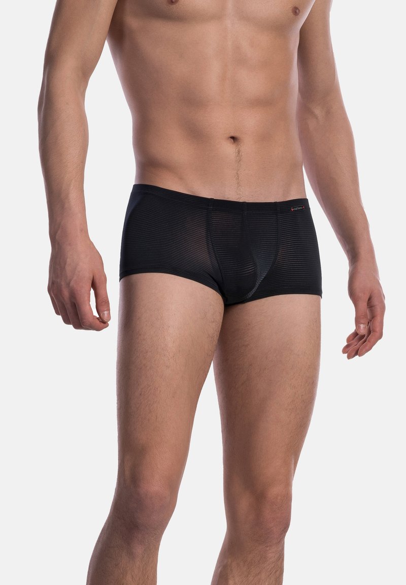 Male torso and upper legs wearing black, semi-transparent striped boxer briefs against a plain light background.