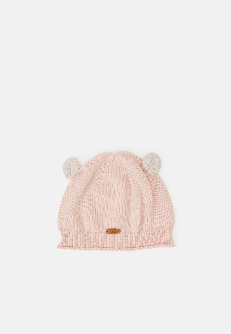 Gorro de malha rosa com uma faixa canelada, apresentando acentos de orelha cinza claro na parte superior e um pequeno etiqueta de madeira com logotipo na frente.