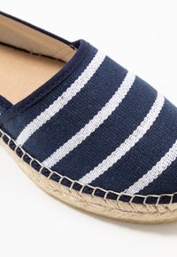 Blå och vit randig canvas-espadrille med en sula i jute och sydda detaljer. Rund tå och mjukt, flexibelt övermaterial.