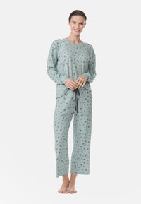 Vaateyhdistelmä vaaleansinisistä pyjamaseteistä, joissa on kukkakuosi; pitkähihainen paita ja suorat housut. Valmistettu pehmeästä kankaasta, jossa on rento istuvuus. Säädettävä vyötärönauha.