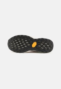 Sort gummisål med et Vibram-logo, der har teksturerede grip-mønstre og et holdbart design. Kontrasterende hvid mellemsål.