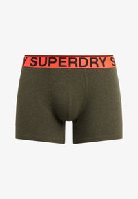 Olivgrüne Baumwoll-Boxershorts mit einem schwarz-orangenen gerippten Bund, auf dem "SUPERDRY" in fetten Buchstaben gedruckt ist.