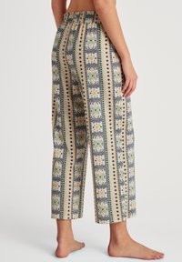 Patterned, lightweight, cropped pants featuring a multicolored design with green, black, and yellow accents. Elastic waistband for comfort.