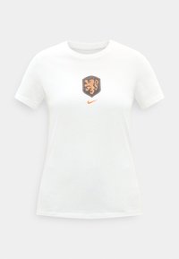 T-shirt blanc à manches courtes avec logo Nike orange et emblème de blason de lion orange centré sur la poitrine.