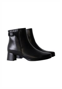 Zwarte enkelboots van soepel leer. Kenmerken zijn een lage blokhak, een zij-inzet van stretch en decoratieve riemdetails rond de enkel.