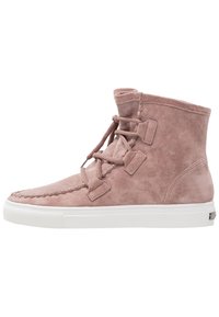 Stivaletti alla caviglia in suede rosa con punta rotonda, caratterizzati da una chiusura con lacci e suola in gomma bianca. Impunture decorative accentuano la zona della punta.