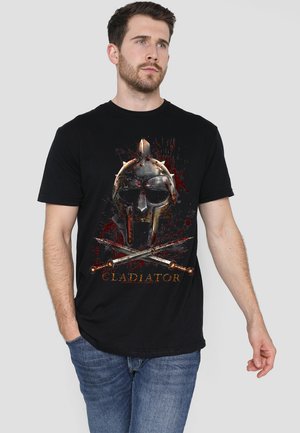 Schwarzes T-Shirt mit einem Grafikdesign eines Gladiatorenhelms, versehen mit roten Spritzern und gekreuzten Schwertern. Es besteht aus Baumwolle, hat kurze Ärmel und einen Rundhalsausschnitt.