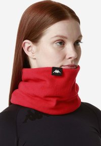 Gaiter da collo in pile rosso con una consistenza morbida, caratterizzato da un'etichetta nera del marchio sul lato. Indossato sopra una maglia nera.