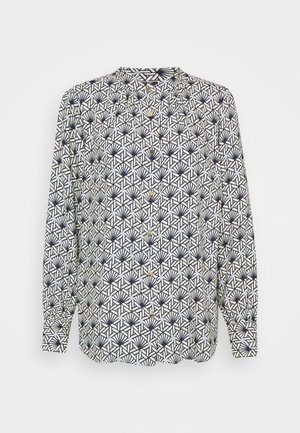 Valkoinen pitkähihainen nappikiinnitteinen pusero, jossa on musta geometrinen ja viuhkamainen kuvio sekä rypytetyt kalvosimet.