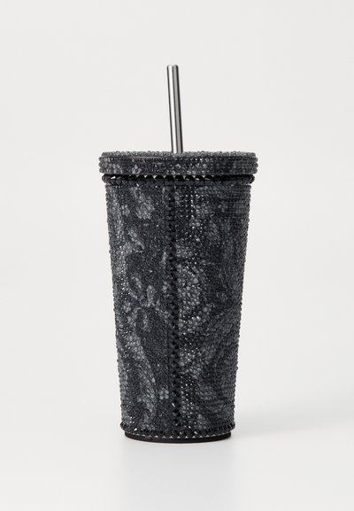 Tazza con accenti di strass neri e cannuccia metallica. Presenta una superficie testurizzata, una forma cilindrica e una decorazione lungo il bordo superiore.