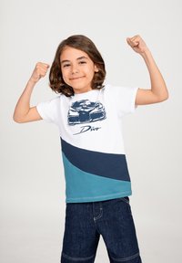 T-shirt per bambini con blocchi di colore bianco, blu navy e teal. Grafica frontale di un'auto con il testo "Divo" sottostante. Maniche corte, collo rotondo.