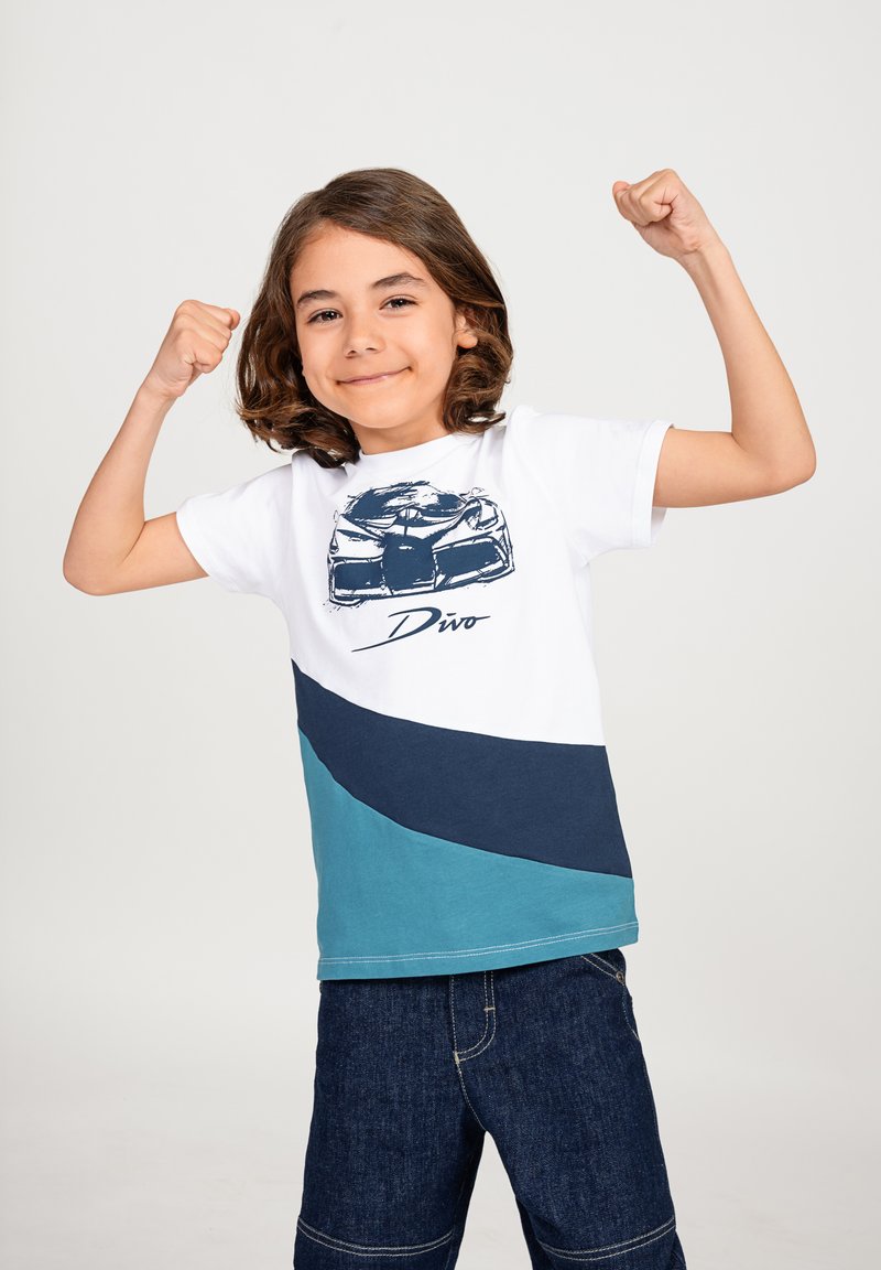 T-shirt per bambini con blocchi di colore bianco, blu navy e teal. Grafica frontale di un'auto con il testo "Divo" sottostante. Maniche corte, collo rotondo.