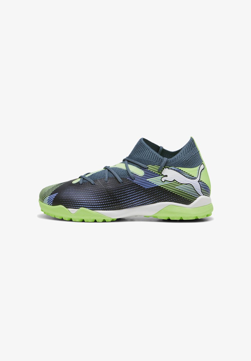 Botas de fútbol Puma en negro, verde y azul con una parte superior de malla texturizada, diseño de media caña y suela de goma adecuada para césped.