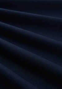 Marineblauer Stoff mit glatter Textur, sanften Falten und schlichtem Design, geeignet für verschiedene Anwendungen.