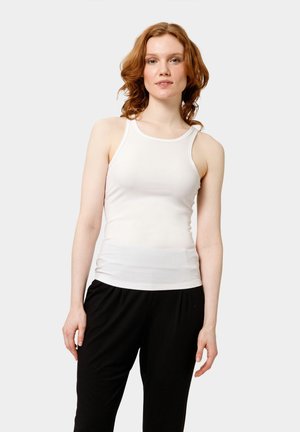Débardeur blanc à côtes avec un col rond et une coupe ajustée, associé à un pantalon noir ample. Design simple et fonctionnel.
