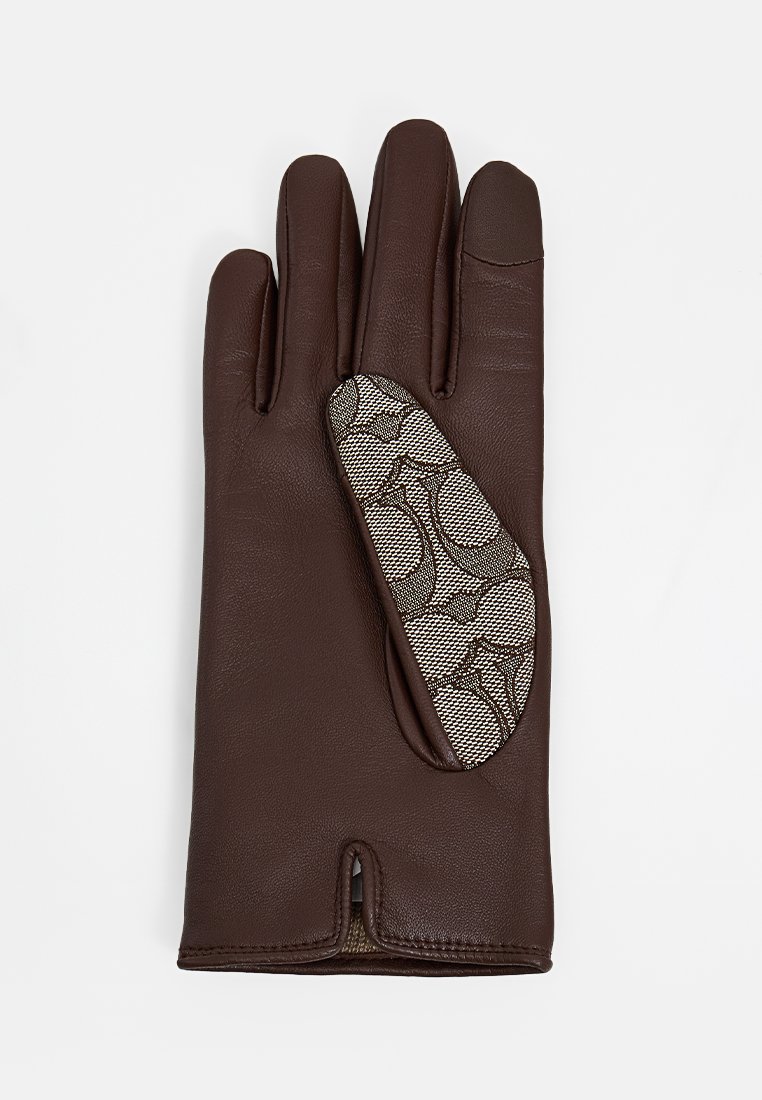 Brązowa skórzana rękawica z akcentem z wzorzystego materiału na dłoni, otwartym mankietem oraz trzema przegródkami na palce. Gładka tekstura.