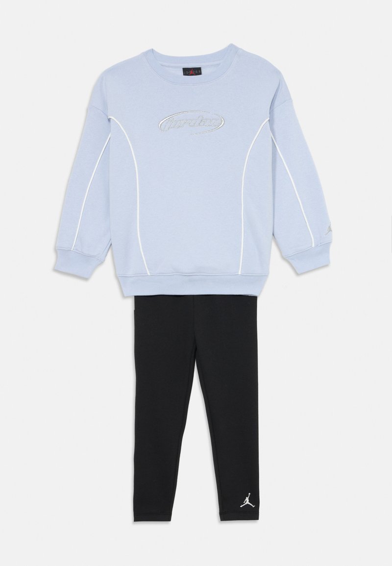 Jasnoniebieska bluza z białymi akcentami i haftem "Jordan", w połączeniu z czarnymi legginsami z białym logo Jordan. Materiał z bawełny.