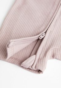 Pink ribbed fabric with a zipper detail at the bottom hem. The fabric is soft with a slight stretch and features a clean finish on edges.