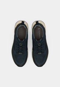 Tumesinine töösussid, millel on võrgusilm ja sünteetilised materjalid, mustade aktsentidega, paeltega ja pehme sisetallaga. Sees on näidatud suurus 40.