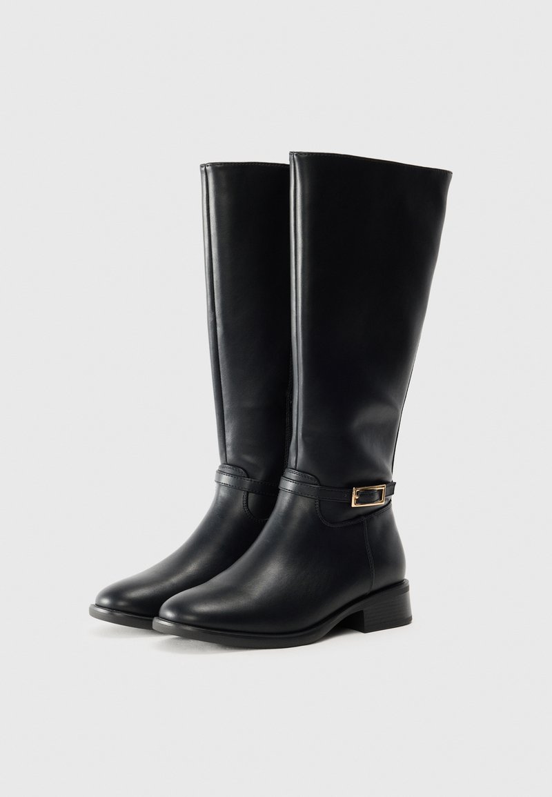 Stivali neri in pelle fino al ginocchio con una finitura liscia, un piccolo dettaglio con fibbia dorata e un tacco basso a blocco. Completati con una punta arrotondata.