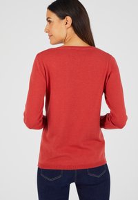 Rode, lange mouw trui met een ronde halslijn, gemaakt van zacht materiaal, met een gladde textuur en een eenvoudig, schoon ontwerp.