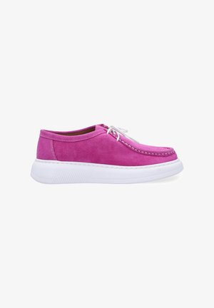 Bright pink suede sneaker with a rounded toe, white rubber sole, and stitched detailing. Features white laces and a low-profile design.