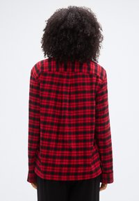 Κόκκ ινο και μαύρο πουκάμισο φανέλας με καρό σχέδιο, διαθέτει άνετη εφαρμογή, μακριά μανίκια και γιακά με κουμπιά. Υφασμένο ύφασμα με υφή και καρό μοτίβο.