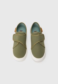 Sapatos de tecido verde com design de tira cruzada, solas de borracha branca e um pequeno detalhe em couro castanho no calcanhar. Forro interior macio.