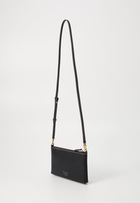 Sort læder crossbody taske med en glat overflade, slank rektangulær form, guld hardware og hvid broderet detalje foran.