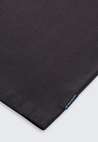 Dark gray cotton fabric with a smooth texture, featuring a stitched hem and a small blue label with "TOM TAILOR" at the edge.