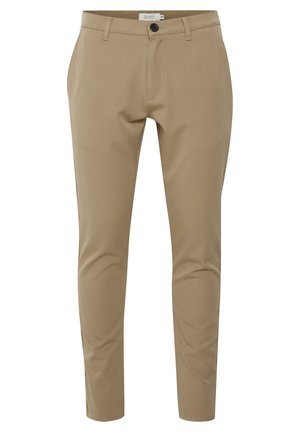 Pantalons beige ajustés avec une coupe slim, présentant une fermeture éclair, des poches avant et une fermeture à un bouton. Texture du tissu lisse.