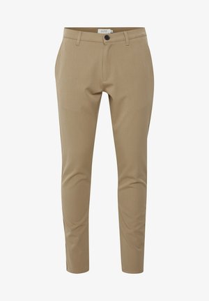 Pantalons beige ajustés avec une coupe slim, présentant une fermeture éclair, des poches avant et une fermeture à un bouton. Texture du tissu lisse.