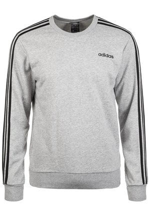 Szara bluza Adidas z okrągłym dekoltem, czarnymi trzema paskami wzdłuż rękawów i logo Adidas na lewym boku klatki piersiowej.