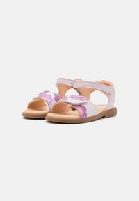 Lilla og rosa barne-sandaler med åpne tær, dekorative blomsterdetaljer, justerbare stropper og en flat, lys tan såle.