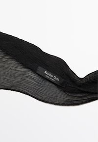 Écharpe plissée noire avec une surface texturée. L'étiquette indique "Massimo Dutti," précisant l'origine comme "Fabriqué en Inde." Les bords sont festonnés.