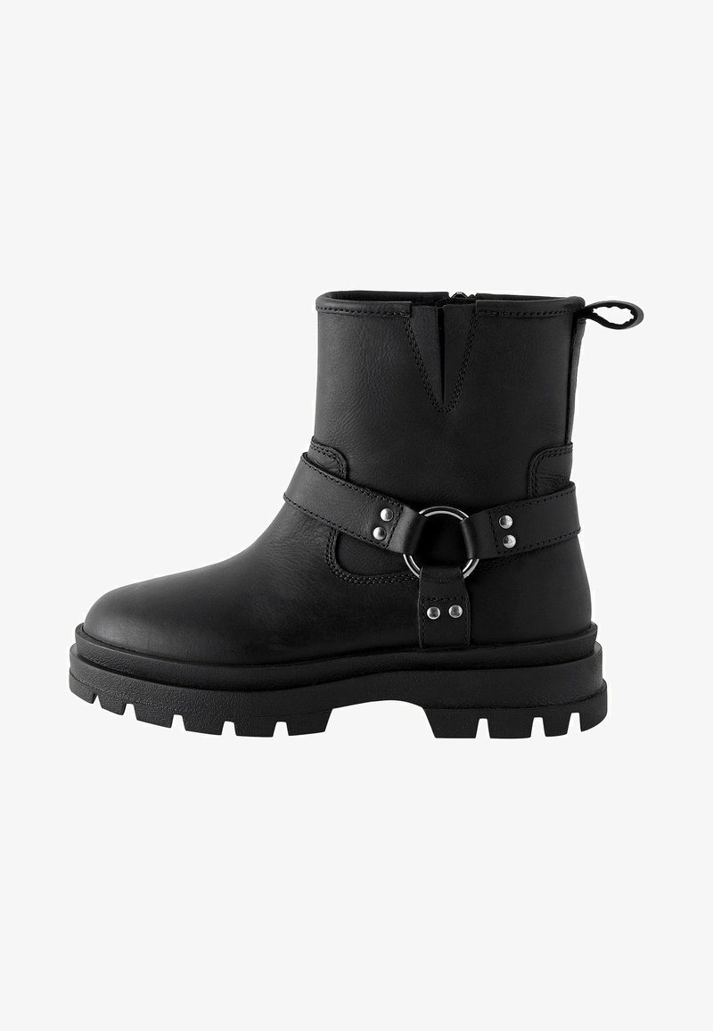 Mustad mustad nahast ankrisaapad, millel on robustne siseosa, külgsel tõmblukk, rihma aktsent metallrõngaga ja tekstureeritud ülemine osa.