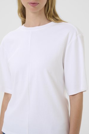 Hvid T-shirt med korte ærmer lavet af blød bomuld, med rund halsudskæring og let tekstur i et rent, minimalistisk design.