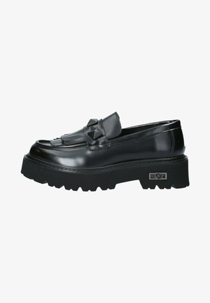 Mocassins en cuir verni noir avec une semelle épaisse et texturée, présentant une frange décorative et des accents en pyramide sur le dessus.